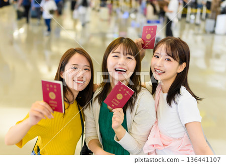 Friends showing their passports at the airport. Photo courtesy of Kansai International Airport (KIX) 136441107