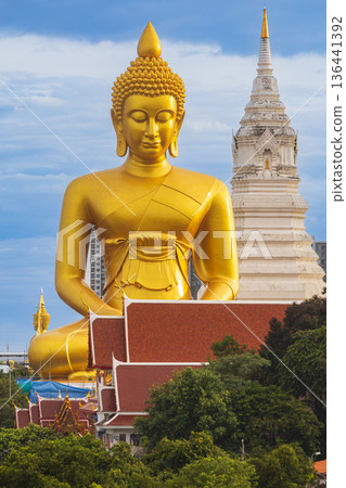 A large seated Buddha or Buddha Dhammakaya Dhepmongkol at Paknam Phasi Charoen temple on a blue sky day. 136441392