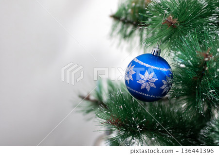 Festive holiday decoration. Cozy festive scene featuring frosted needles and reflective bauble Festive holiday decoration. Cozy festive scene featuring frosted needles and reflective bauble 136441396