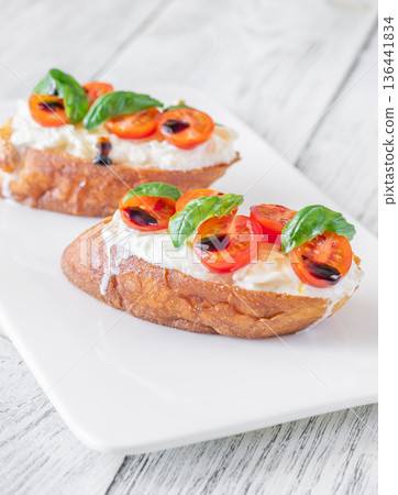 Gourmet bruschetta with stracciatella cherry tomatoes basil and balsamic on bright rustic background Gourmet bruschetta with stracciatella cherry tomatoes basil and balsamic on bright rustic background 136441834
