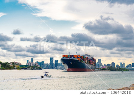 Miami, Florida, USA - June 07, 2024: Container ship. Shipping logistics. Cargo ship with container in Miami skyline. Freight container loaded on cargo vessel in Miami. Cargo ship leaving harbor 136442018