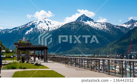 Skagway, Alaska, USA - July 07, 2019: Small boat harbor. Mountain landscape with snowy peaks. Landscape of Alaska, Skagway. Scenic landscape with mountain of Small boat harbor Skagway, Alaska, USA - July 07, 2019: Small boat harbor. Mountain landscape with snowy peaks. Landscape of Alaska, Skagway. Scenic landscape with mountain of Small boat harbor 136442032
