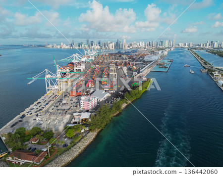 Miami, Florida, USA - June 06, 2024: Container terminal with stored cargo and port equipment. Miami beach cargo harbor with cityscape. Cargo berth in Miami beach, Florida. 136442060