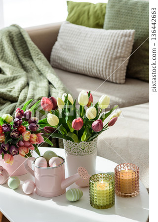 Easter Table with Tulip Bouquets, Eggs, Candles and Festive Decor. Cozy Spring Arrangement Easter Table with Tulip Bouquets, Eggs, Candles and Festive Decor. Cozy Spring Arrangement 136442663