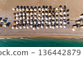 Drone top view of organized beach umbrellas and sunbeds near turquoise sea coastline on sunny summer day travel vacation concept 136442879