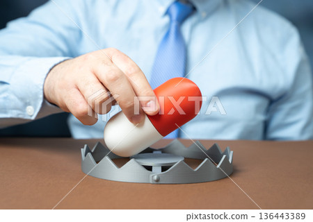 A medicinal capsule as bait in a trap. Side effects. Development of dependence on medications and painkillers. Responsible prescribing and monitoring reduce risk and support patient safety. 136443389