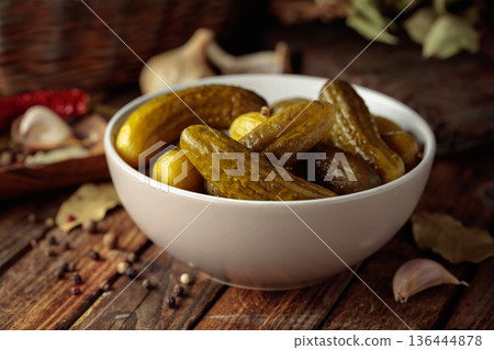 Homemade canned gherkins on a rustic wooden background. 136444878