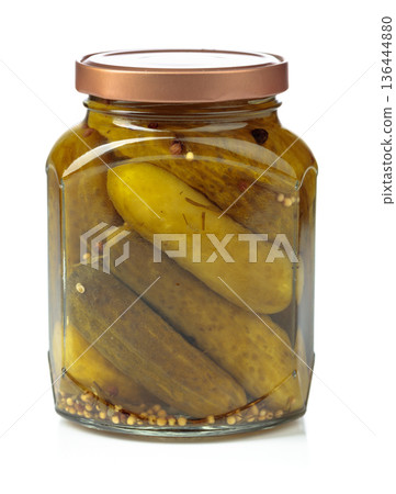 Homemade pickled cucumbers in a glass jar isolated on a white background. Homemade pickled cucumbers in a glass jar isolated on a white background. 136444880