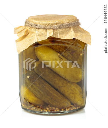 Homemade pickled cucumbers in a glass jar isolated on a white background. Homemade pickled cucumbers in a glass jar isolated on a white background. 136444881