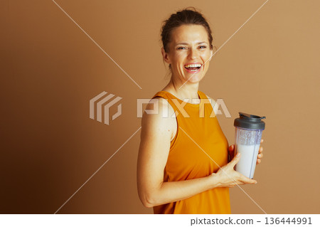 Cheerful Woman with Protein Shake and Yellow Top Cheerful Woman with Protein Shake and Yellow Top 136444991