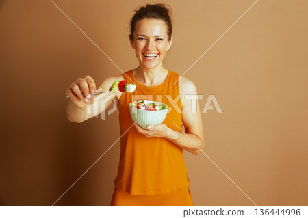 Woman Offering Healthy Salad with a Smile Woman Offering Healthy Salad with a Smile 136444996