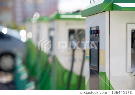 Close-up of an electric vehicle charging station with indicator lights and display. 136445178