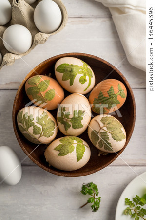 DIY Easter eggs with natural leaves, creating patterns on eggs using plants. Eco friendly colouring easter eggs 136445396