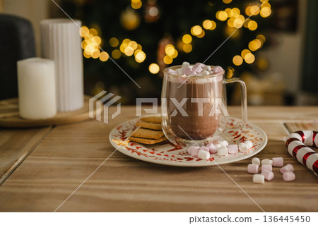 Holiday, Christmas background. A cup with hot chocolate and marshmallows on the table with Christmas tree on background 136445450