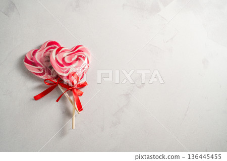 Valentine's Day festive background. Heart-shaped lollipops on grey background with copy space. Love concept 136445455