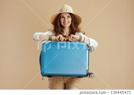 happy stylish woman in blouse and shorts against beige 136445475