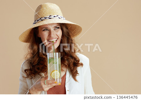 smiling trendy woman in blouse and shorts on beige 136445476