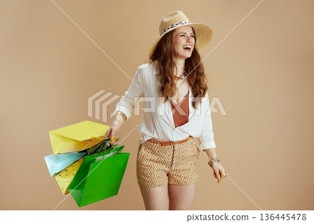 happy elegant woman in blouse and shorts isolated on beige 136445478
