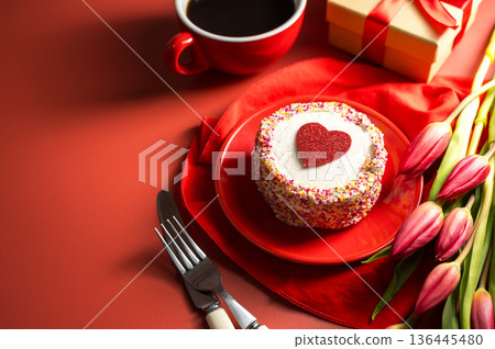 Valentine's Day festive red background. Cake with red heart, cup of coffee, gift box and spring red tulip flower bouquet. Top view 136445480