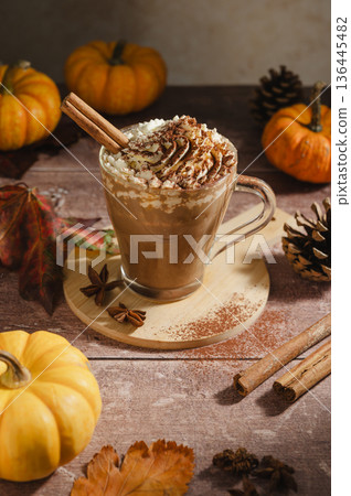 Pumpkin spice latte, coffee drink in glass cup with pumpkins, autumn hot drink Pumpkin spice latte, coffee drink in glass cup with pumpkins, autumn hot drink 136445482