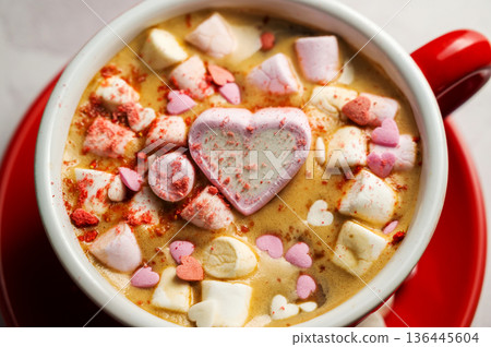 Valentine's Day background. Red cup of coffee with heart shaped marshmallows Valentine's Day background. Red cup of coffee with heart shaped marshmallows 136445604