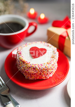 Valentine's Day festive red background. Cake with red heart, cup of coffee, gift box and gypsophila flower 136445616