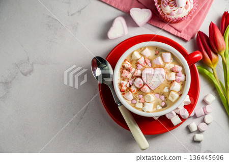 Valentine's Day background. Red cup of coffee with heart shaped marshmallows and ret tulips Valentine's Day background. Red cup of coffee with heart shaped marshmallows and ret tulips 136445696