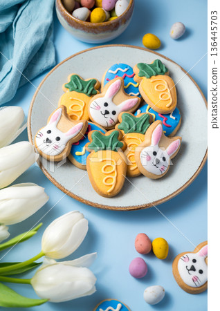 Easter spring holiday background with easter cookies in a plate: buny, carrot and egg with white tulips in a vase 136445703
