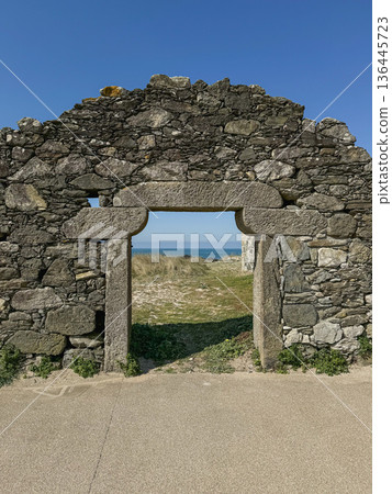 Stone coastal gateway near Praia De Paco in Carreco, Caminha, Portugal with Atlantic ocean visible through rustic masonry opening. Travel, destination, coastal tourism, cultural heritage storytelling 136445723