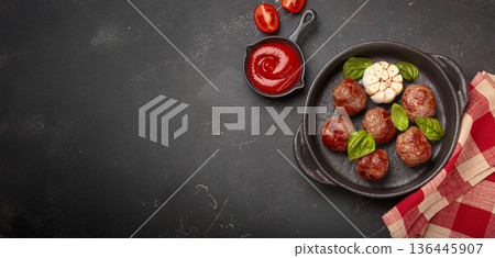 Delicious fried meatballs with basil, garlic in cast iron pan and tomato sauce top view, copy space Delicious fried meatballs with basil, garlic in cast iron pan and tomato sauce top view, copy space 136445907
