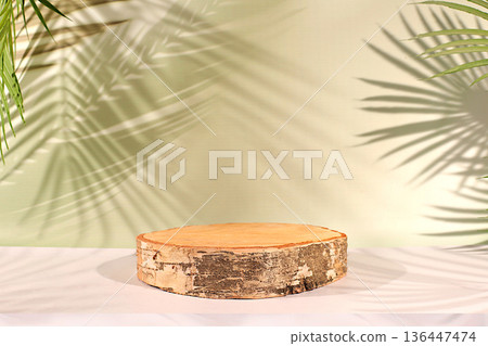 Empty birch podium for cosmetics displays atop an elegant, sunny, colorful banner against a backdrop of long palm leaf shadows. The perfect template for your creative work, summer party concept Empty birch podium for cosmetics displays atop an elegant, sunny, colorful banner against a backdrop of long palm leaf shadows. The perfect template for your creative work, summer party concept 136447474