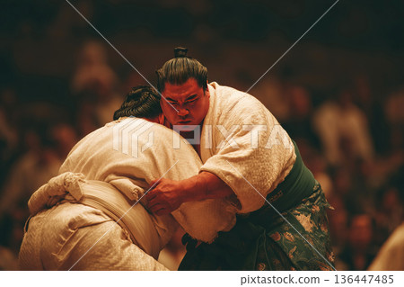 Sumo wrestler lifts opponent with a powerful throw during a traditional match in Japan 136447485