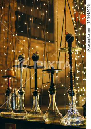 Row Of Hookahs With Glowing Charcoal Under Fairy Lights Row Of Hookahs With Glowing Charcoal Under Fairy Lights 136448006