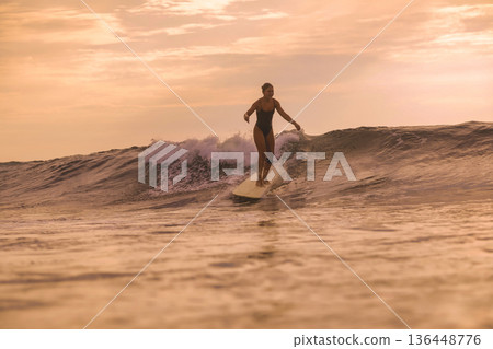 Instructor Demonstrating Longboard Techniques In Peaceful Sunset Environment 136448776