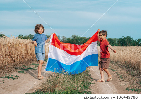 Children Standing With Flag Of Netherlands On Open Wheat Road Field.Happy Future 136449786