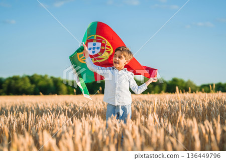 Patriot Little Boy Holding Portuguese Flag In Wheat Field, Symbolizing Pride Patriot Little Boy Holding Portuguese Flag In Wheat Field, Symbolizing Pride 136449796