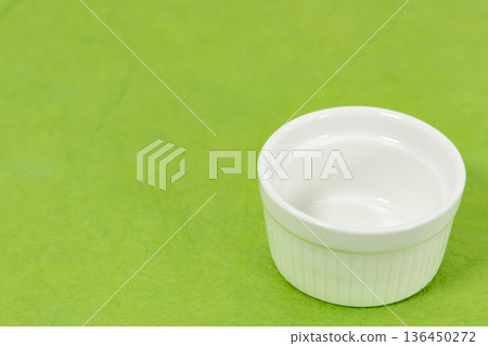 A white cocotte dish placed on a yellow-green background 136450272