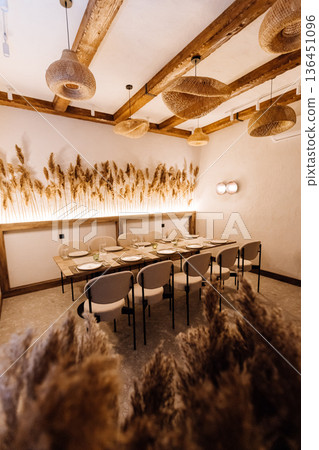 Cozy private dining room with rattan pendants and pampas decor, set table Cozy private dining room with rattan pendants and pampas decor, set table 136451096