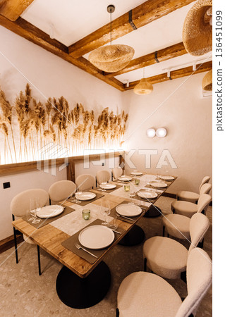 Cozy private dining room with rattan pendants and pampas decor, set table Cozy private dining room with rattan pendants and pampas decor, set table 136451099