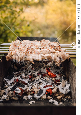 Pork kebabs grilling on skewers over charcoal barbecue, outdoor picnic 136451121
