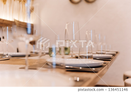 Wine glass on set restaurant table with warm candlelight and pampas decor 136451146