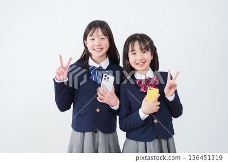 學生用智慧型手機比劃和平手勢 學生用智慧型手機比劃和平手勢 136451319