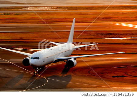 A passenger plane seen from the front on the runway in the evening A passenger plane seen from the front on the runway in the evening 136451359