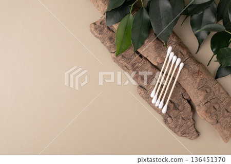 Wood cotton swabs on natural bark, green leaves Wood cotton swabs on natural bark, green leaves 136451370