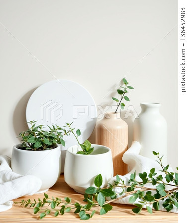 Elegant Still Life with Plants, Vases, and a White Plate on a Wooden Table 136452983
