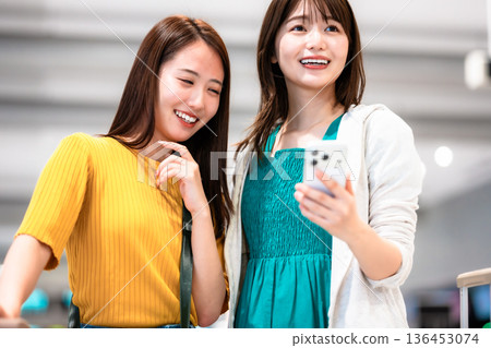 A friend looking at a smartphone at the airport. Photo courtesy of Kansai International Airport (KIX) A friend looking at a smartphone at the airport. Photo courtesy of Kansai International Airport (KIX) 136453074