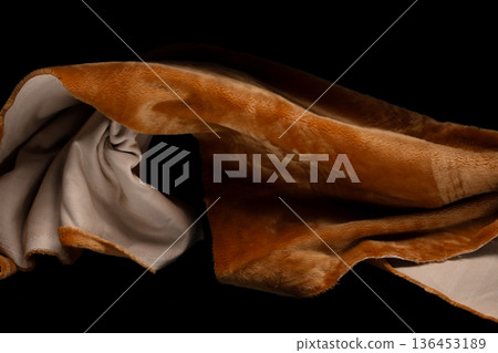 Brown gold wool fabric flying in curve shape, Piece of textile Brown gold wool fabric throw fall in air. Black background isolated, dark shading environment Brown gold wool fabric flying in curve shape, Piece of textile Brown gold wool fabric throw fall in air. Black background isolated, dark shading environment 136453189