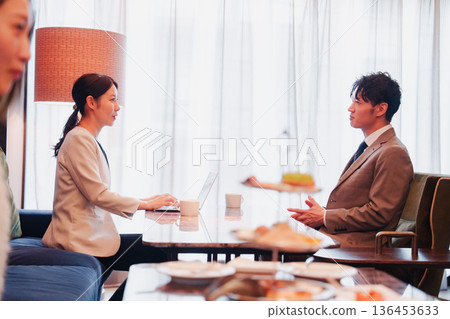 Male and female business people having a business meeting in a lounge 136453633