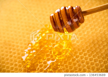 Macro shot of natural honey drop dripping from the honeycomb. Macro shot of natural honey drop dripping from the honeycomb. 136453689