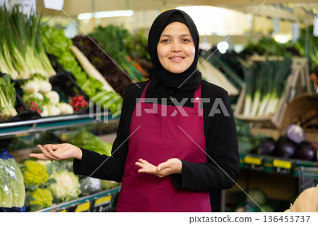 Young woman seller in hijab posing in grocery store Young woman seller in hijab posing in grocery store 136453737